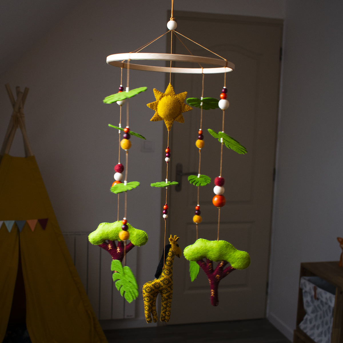 mobile girafe fait main dans une chambre de bébé